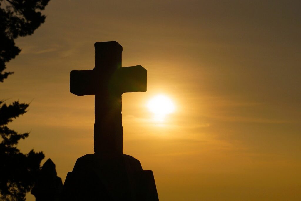Silhouette of a stone cross at sunset.
Image by sspiehs3 from Pixabay 
