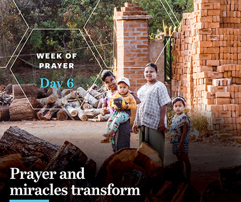 Photo of a family standing amid bricks and logs with the words, Week of Prayer Day 6, Prayer and Miracles Transform. Photo by IMB