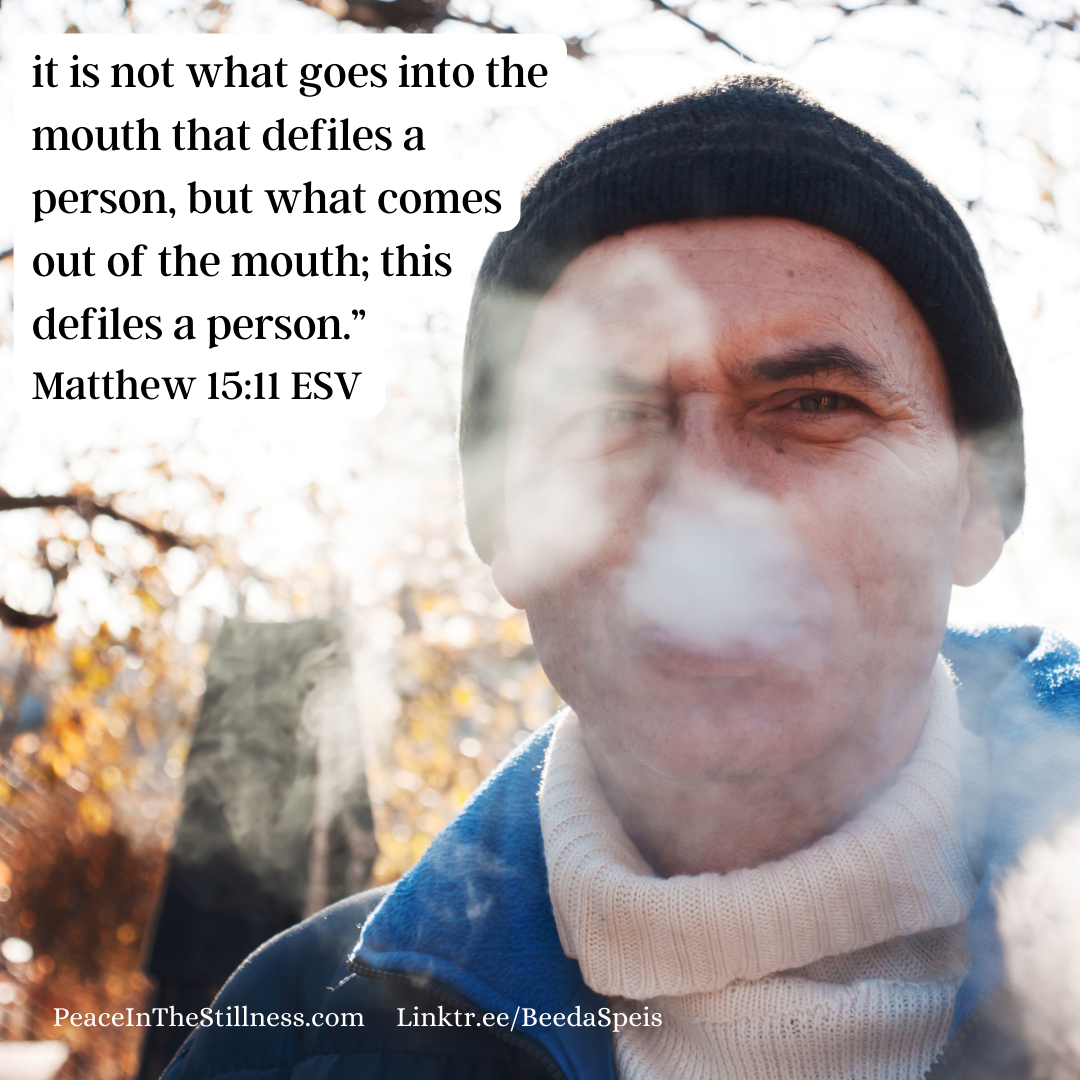 A photo of a man. You can see his breath. Above him are the words to Matthew 15:11 ESV